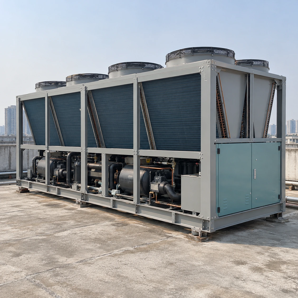 Grey and teal industrial air-cooled chiller on a factory roof with accessible condenser banks
