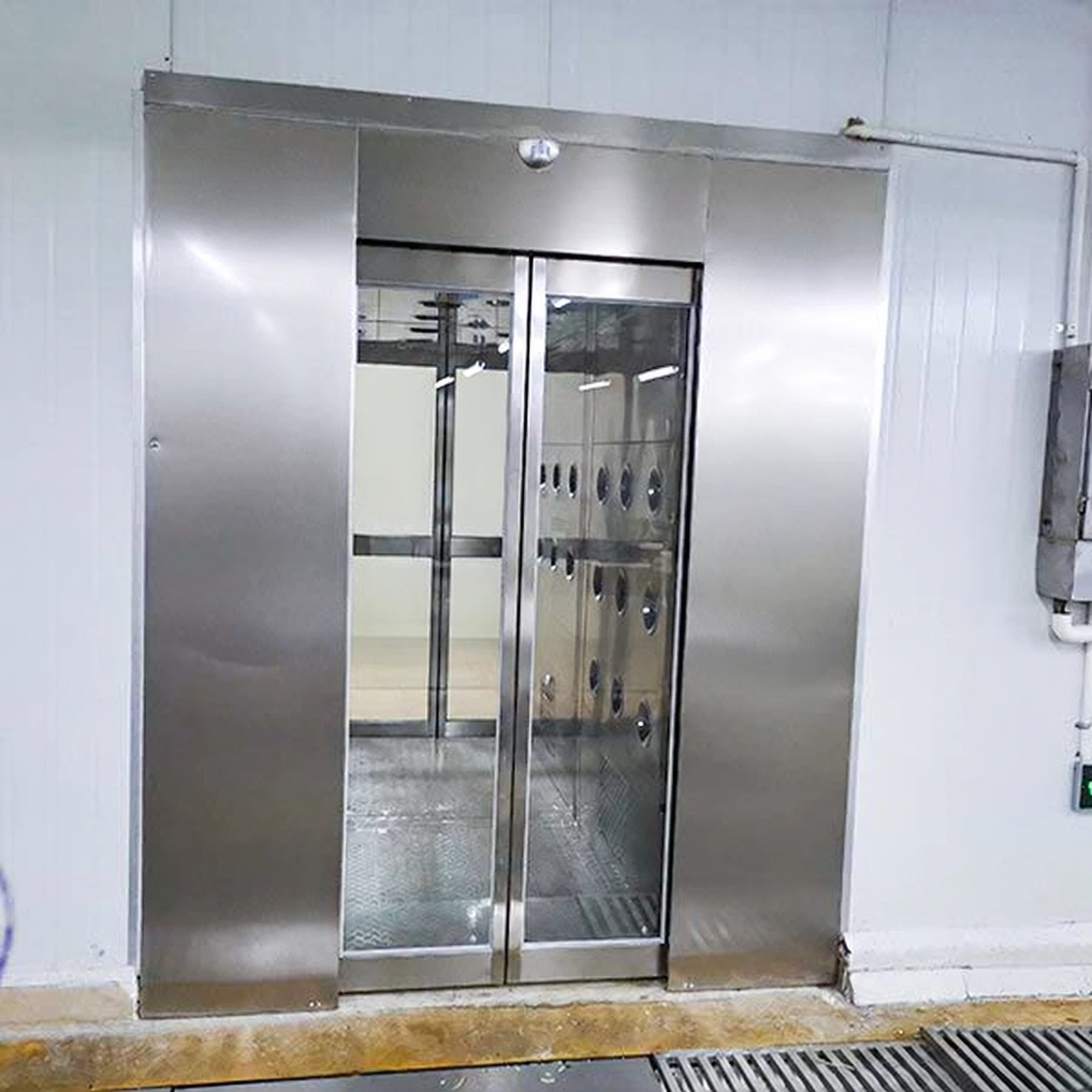 Sliding-door air shower fitted into an industrial room entrance