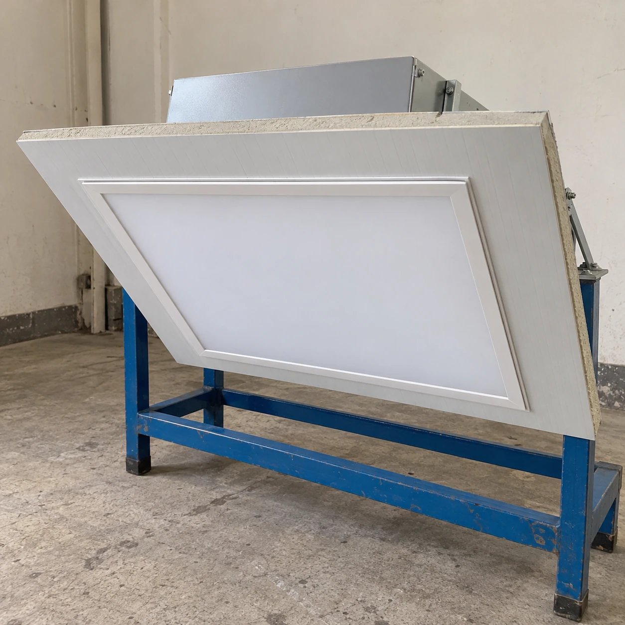 Recessed cleanroom luminaire fitted flush into a ceiling panel section on a workshop stand