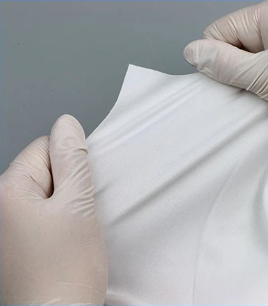 1006S Pre-Saturated Polyester Wipes — Knitted wipe held between gloved hands