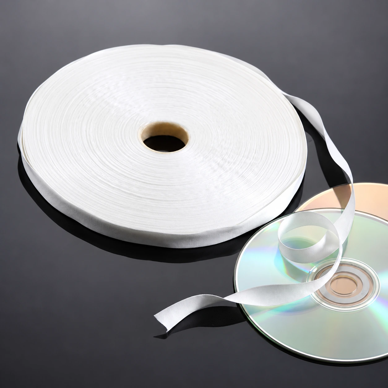 S4009 narrow white wiping roll with loose ribbon beside optical discs